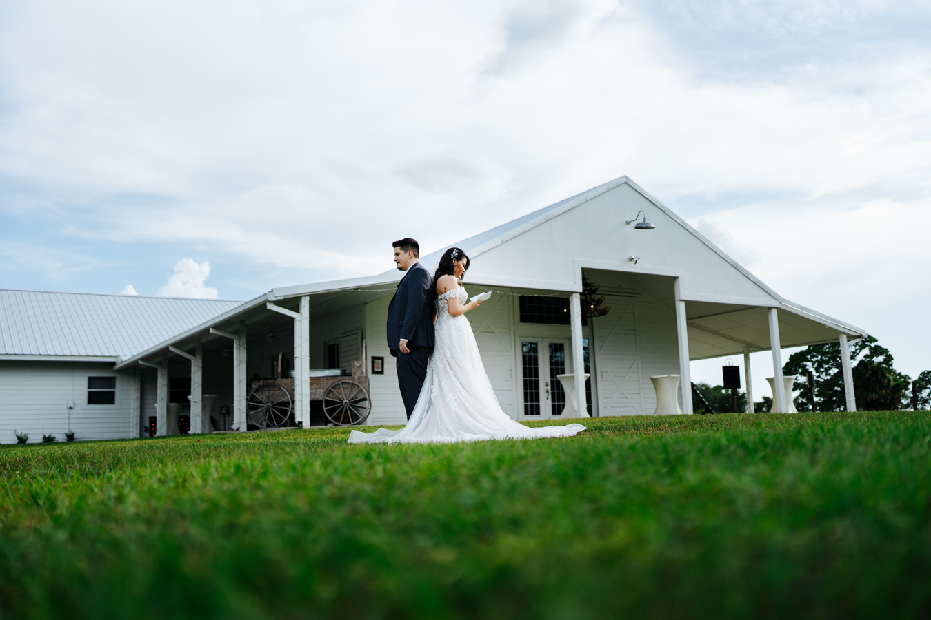 Bride and groom reading vows in front of the farm